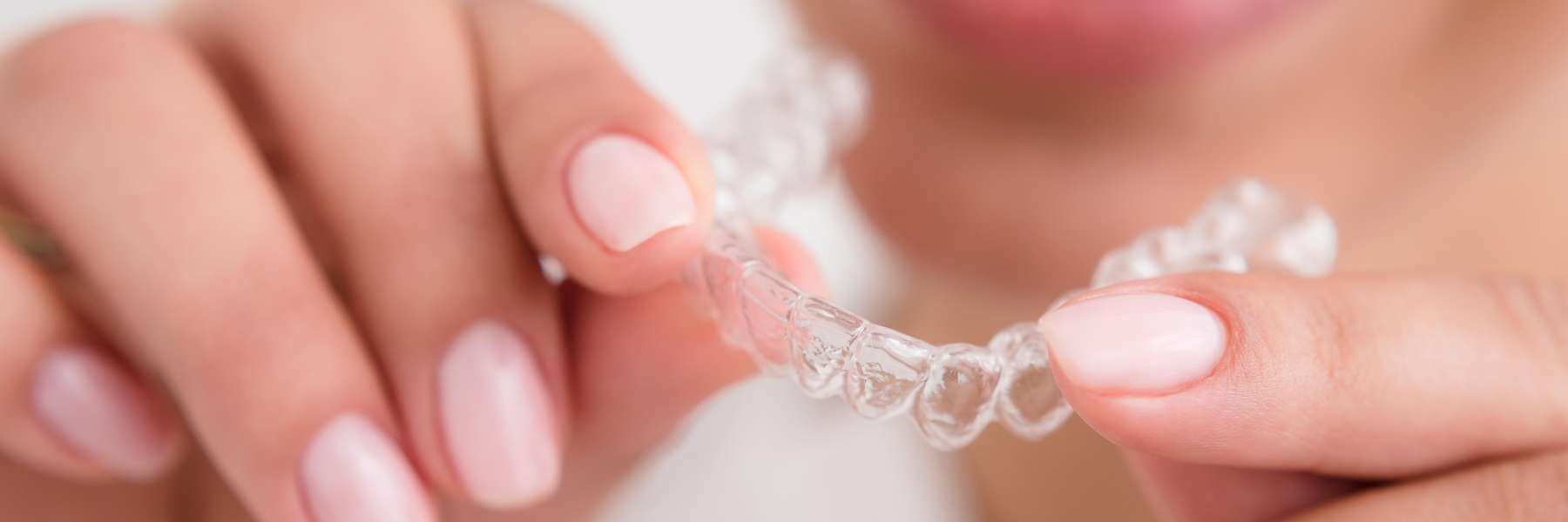 Lady holding Invisalign clear aligners at Randolph Dental Associates
