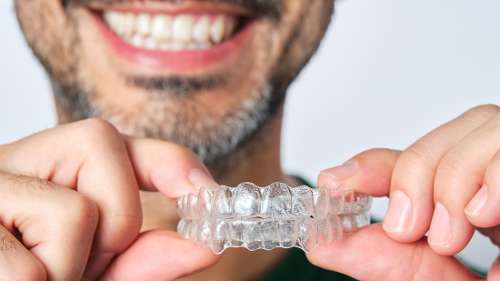 A man holding Invisalign clear aligners in Randolph NJ