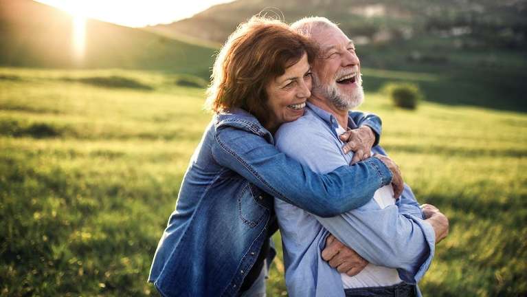 Couple smiling after getting dental implants from Randolph Dental Associates