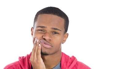 Man holding jaw from TMJ pain in Randolph, NJ
