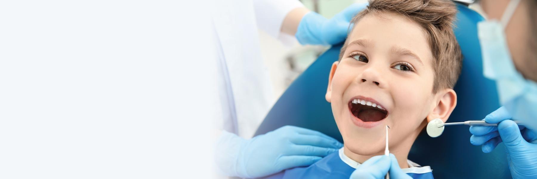 young boy smiling in dental chair